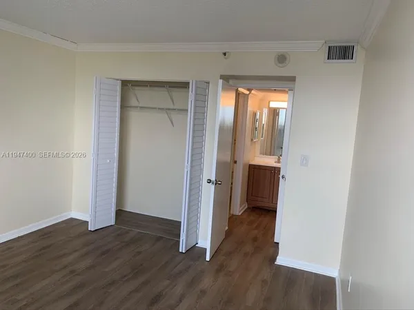an empty room with wooden floor and a window