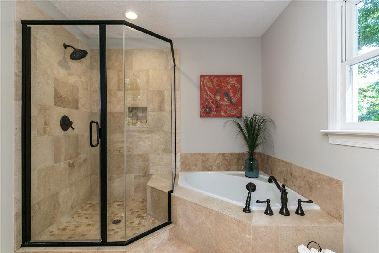 4908 Fielding Drive Raleigh, NC 27606 - Photo 16 of 25 The master bathroom has been so beautifully renovated! The corner garden tub is perfect for a relaxing soak and the shower is so beautiful finished off with oil-rubbed bronze frame and fixtures. Master Bathroom