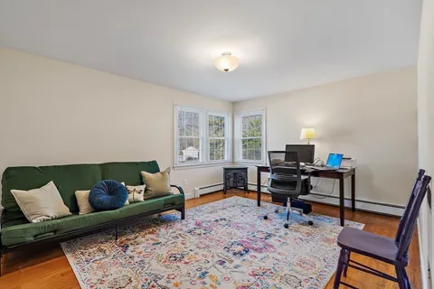 a living room with furniture a rug and a window