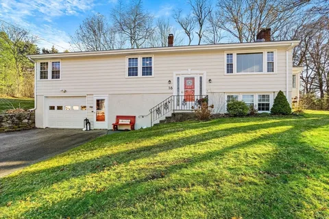 a view of a white house with a yard and plants