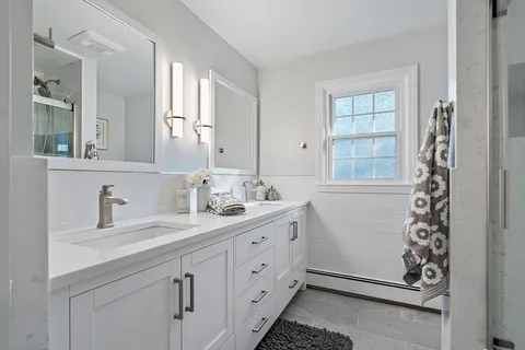 a spacious bathroom with double vanity and a mirror
