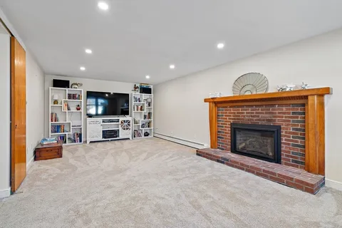 a living room with furniture a fireplace and a flat screen tv