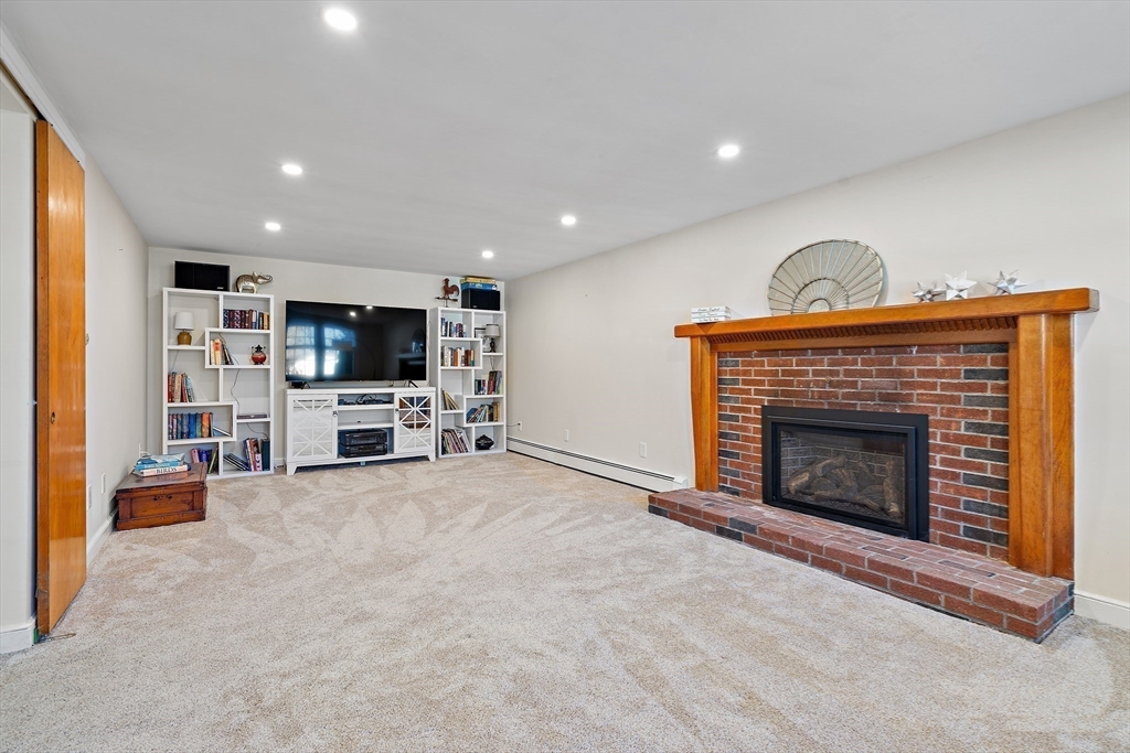 16 Beaudry Street Marlborough, MA 01752 - Photo 25 of 40 a living room with furniture a fireplace and a flat screen tv