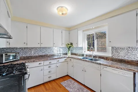 a kitchen with granite countertop a sink stainless steel appliances and cabinets