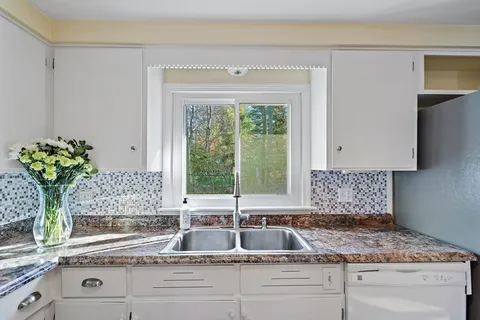 a kitchen with granite countertop a sink and a window