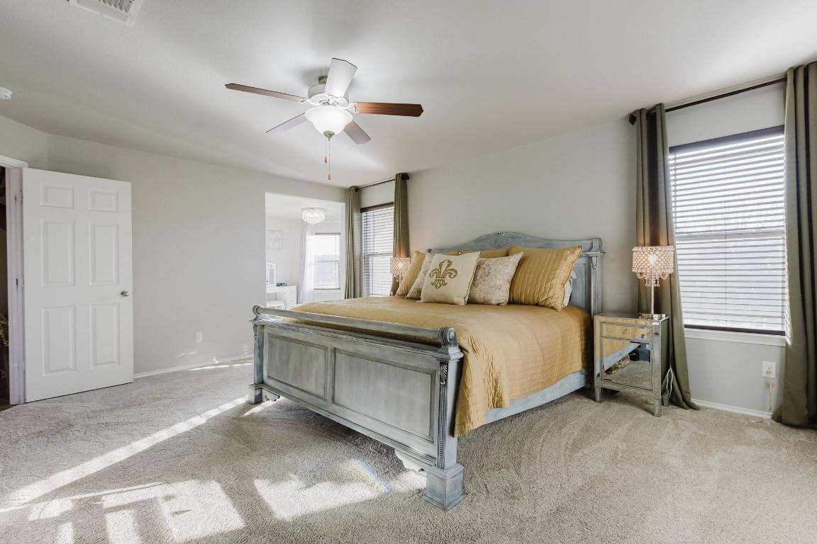 1420 Crested Butte Way Georgetown, TX 78626 - Photo 20 of 40 Primary Bedroom featuring light carpet, ensuite bath, and ceiling fan