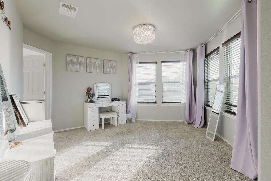 1420 Crested Butte Way Georgetown, TX 78626 - Photo 23 of 40 Primary Bedroom featuring light carpet, ensuite bath, and ceiling fan