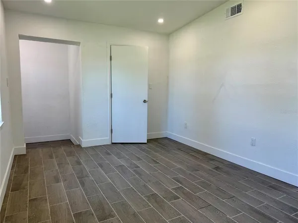 a view of an empty room with wooden floor