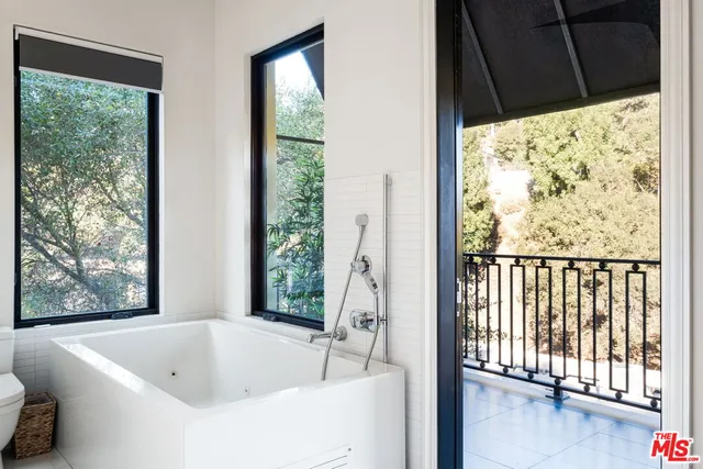 a bathroom with a bathtub and next to a window