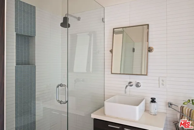 a bathroom with a sink a mirror and shower