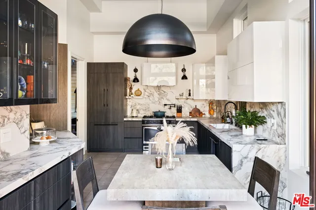 a kitchen with a sink a stove and chairs