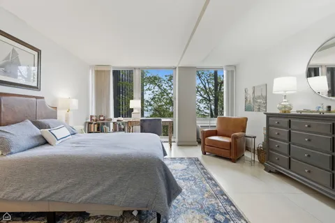 a bedroom with a bed and large windows
