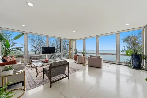 a living room with furniture a flat screen tv and a large window