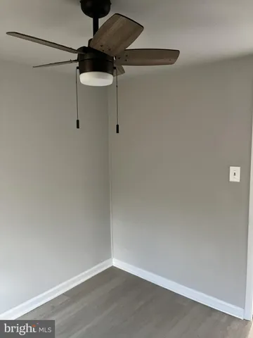 a small space with a fan and wooden floor