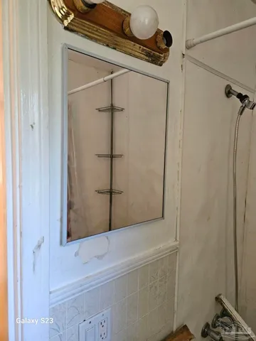 a bathroom with a shower and a mirror