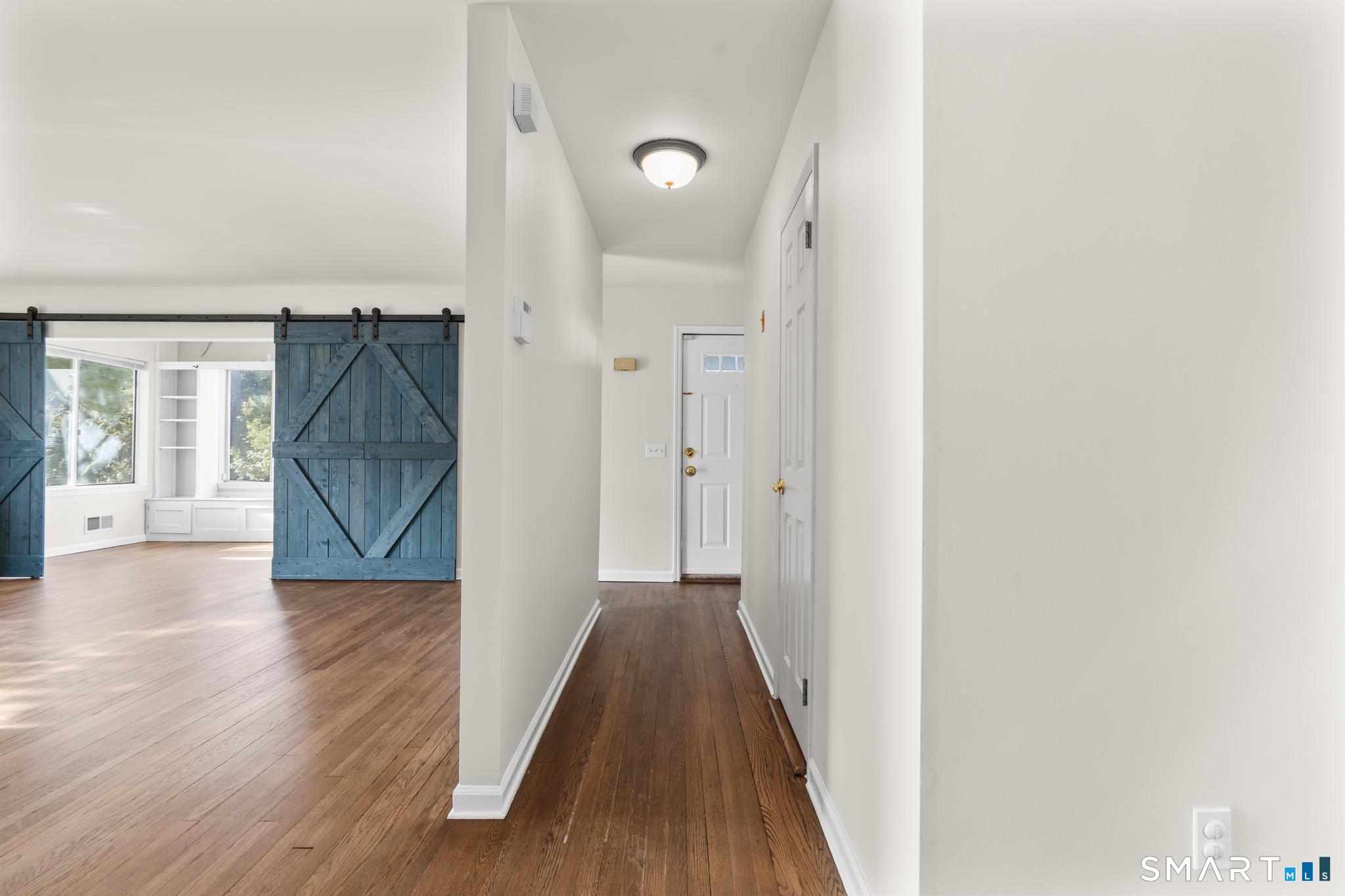 254 Seaside Avenue, Unit A Stamford, CT 06902 - Photo 11 of 28 a view of a hallway with wooden floor and a bathroom