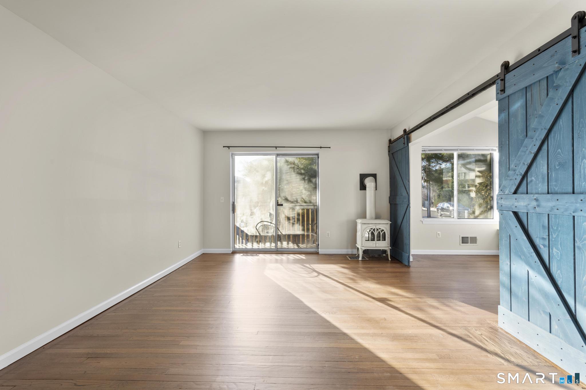 254 Seaside Avenue, Unit A Stamford, CT 06902 - Photo 6 of 28 a view of an empty room with wooden floor and a window