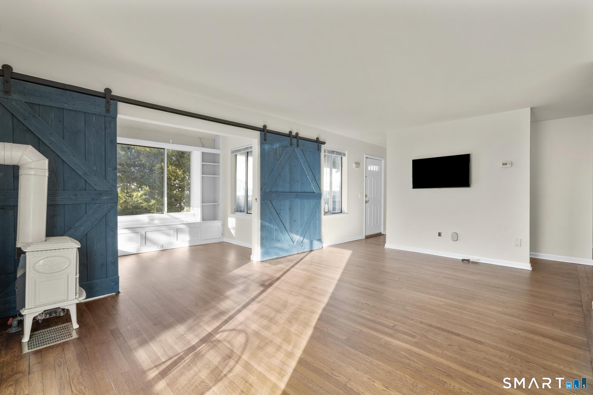 254 Seaside Avenue, Unit A Stamford, CT 06902 - Photo 8 of 28 a view of an empty room with wooden floor and a window