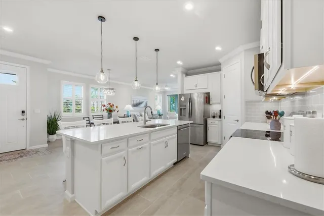 a kitchen with kitchen island granite countertop stainless steel appliances a sink a stove and cabinets