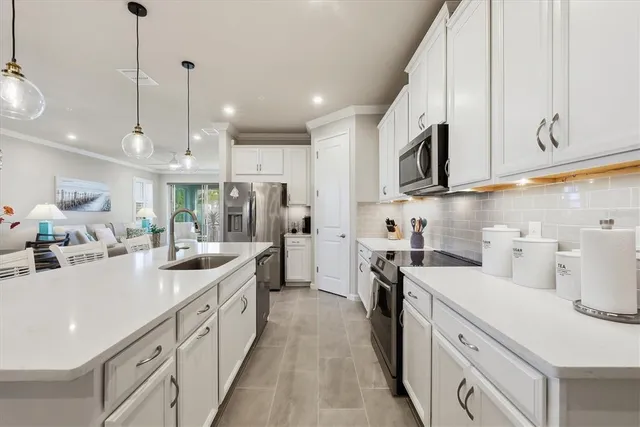 a kitchen with stainless steel appliances granite countertop a sink a stove and a wooden floors