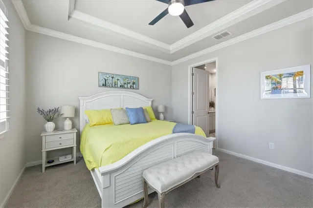 a spacious bedroom with a bed a chandelier and a large window
