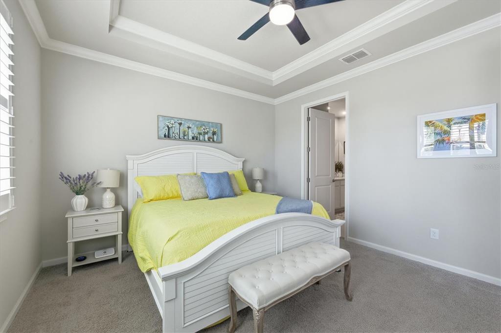 12333 Asana Court Venice, FL 34293 - Photo 17 of 58 a bedroom with a bed and a chandelier