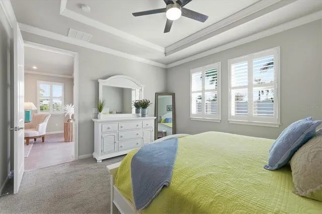 a bedroom with a bed a chandelier and a window