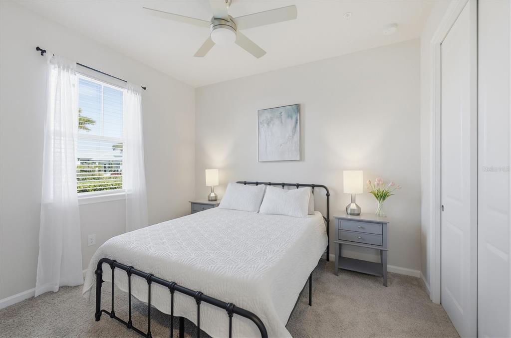 12333 Asana Court Venice, FL 34293 - Photo 19 of 58 a bedroom with a bed a chandelier and a window