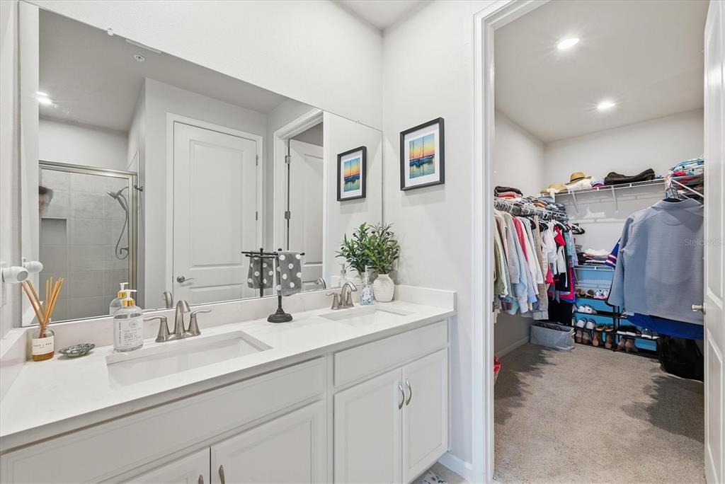 12333 Asana Court Venice, FL 34293 - Photo 24 of 58 a bathroom with double vanity sinks a mirror and a shower