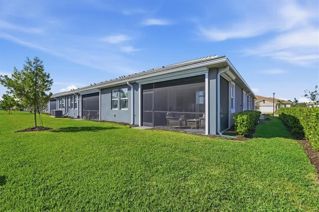 a front view of a house with a yard and potted plants