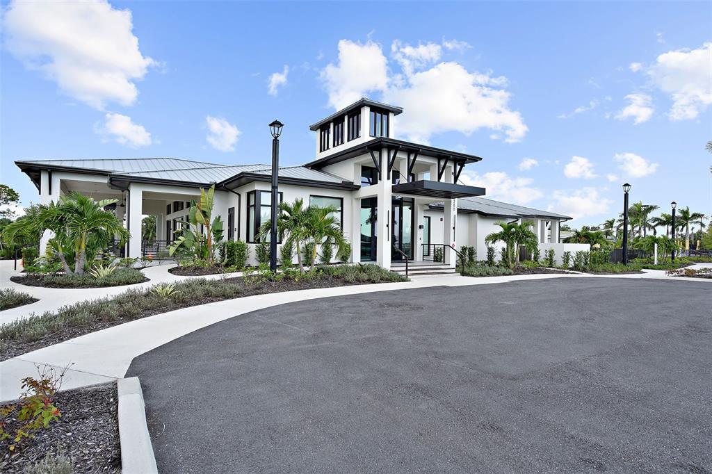 12333 Asana Court Venice, FL 34293 - Photo 33 of 58 a front view of a house with a yard and potted plants