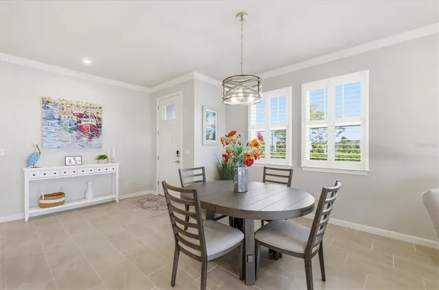 a view of a dining room with furniture a chandelier and wooden floor