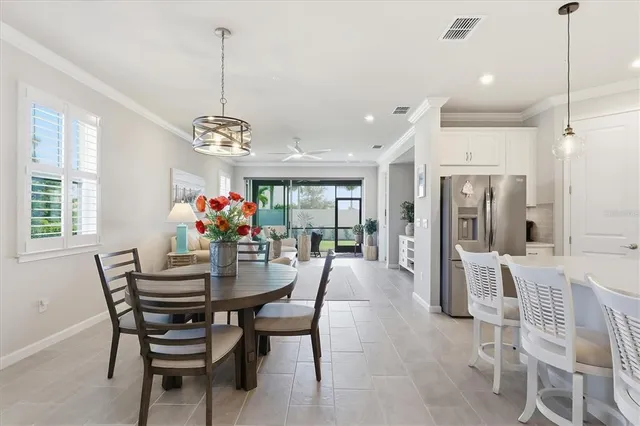 a view of a dining room and livingroom with furniture wooden floor a chandelier