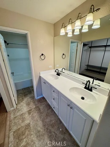 a spacious bathroom with a double vanity sink and a mirror
