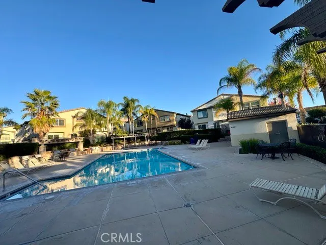 a swimming pool with outdoor seating and a potted plant