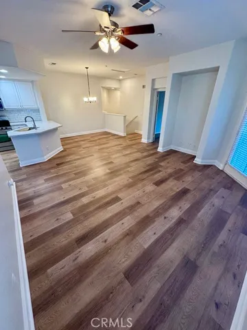 a view of an empty room and a kitchen