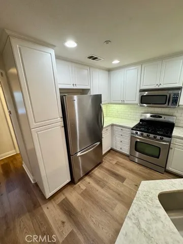 a kitchen with a refrigerator a stove and a sink