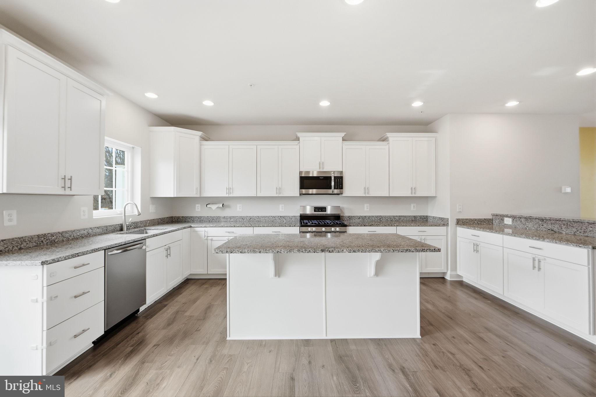 3623 Duckhorn Way Laurel, MD 20724 - Photo 19 of 48 a kitchen with stainless steel appliances granite countertop a stove top oven a sink dishwasher and white cabinets with wooden floor