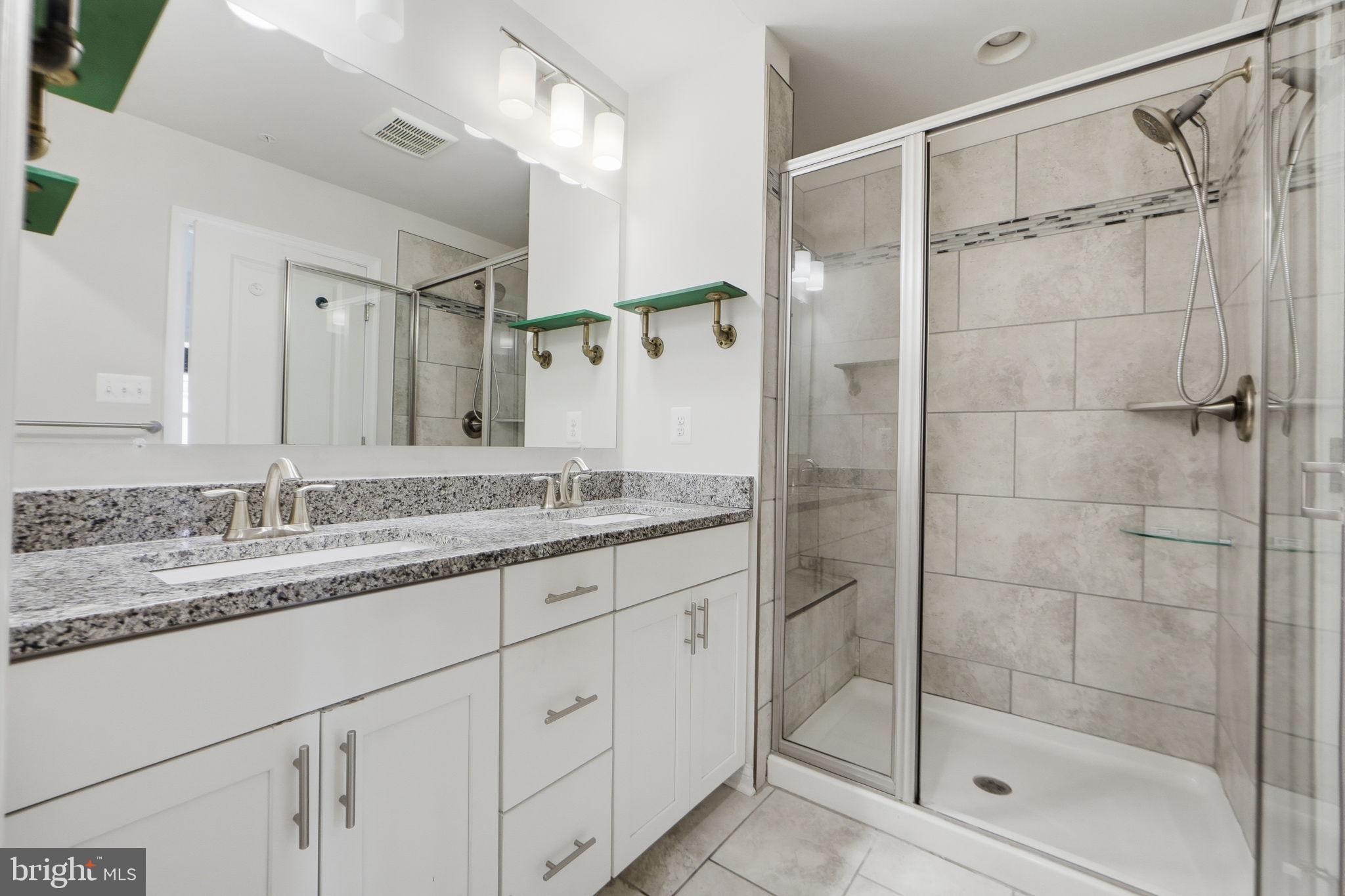 3623 Duckhorn Way Laurel, MD 20724 - Photo 29 of 48 a bathroom with a granite countertop sink a mirror a glass door and shower