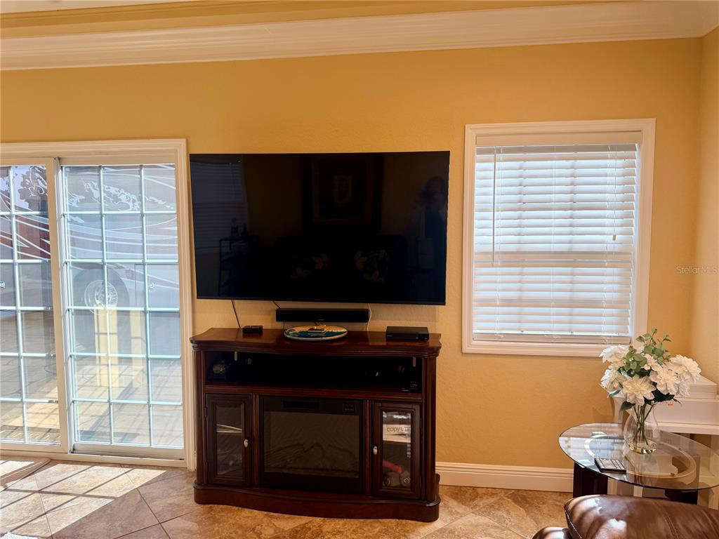 9516 Southeast 47th Way Webster, FL 33597 - Photo 21 of 43 a living room with a fireplace and a flat screen tv