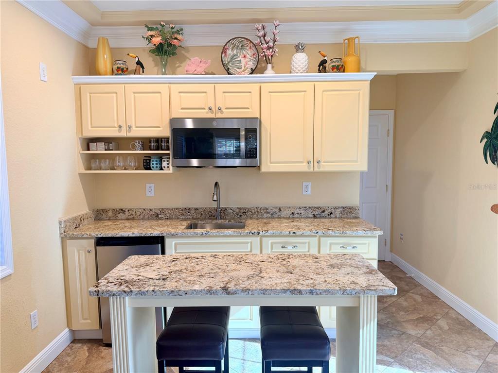 9516 Southeast 47th Way Webster, FL 33597 - Photo 24 of 43 a kitchen with a stove a microwave and wooden cabinets