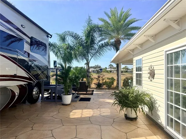a view of a patio with table and chairs potted plants with palm trees