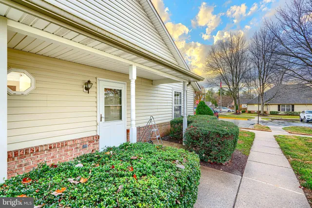 a front view of a house with a yard and potted plants