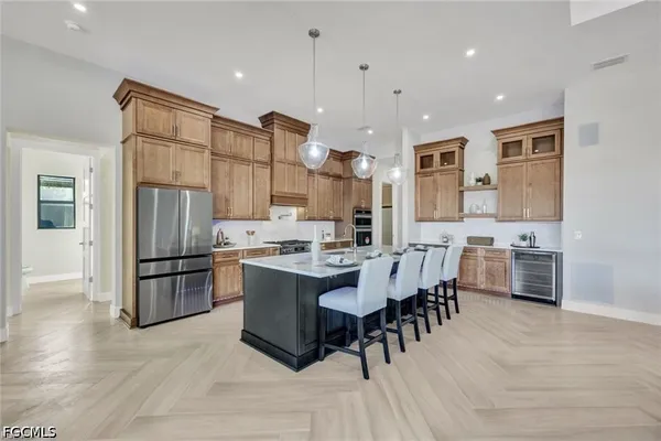 a kitchen with stainless steel appliances kitchen island granite countertop a refrigerator and a stove top oven