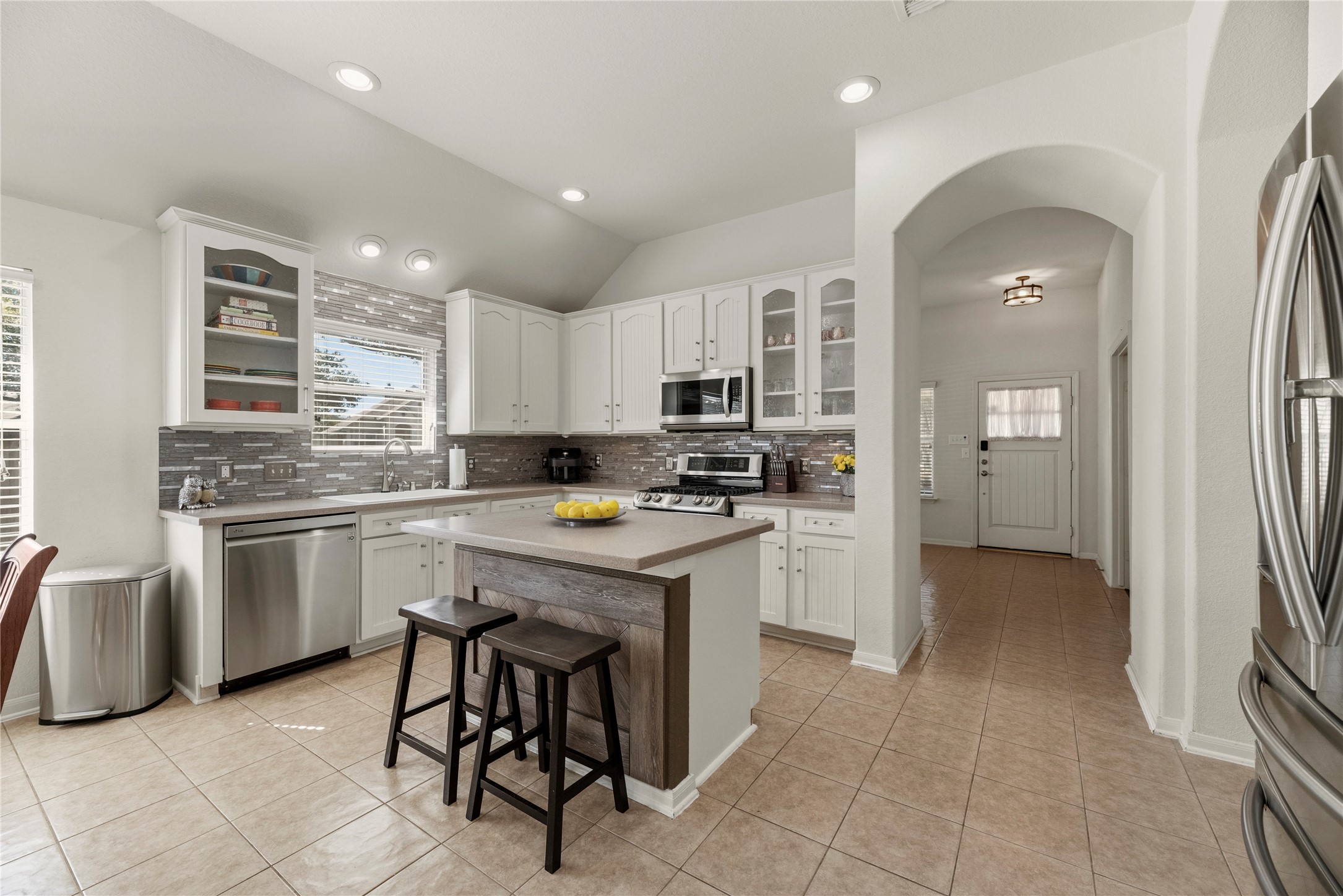 5727 Valley Scene Way Spring, TX 77379 - Photo 13 of 37 This modern kitchen features white cabinetry, stainless steel appliances, and a stylish tile backsplash. There's a kitchen island,
great natural light from the window.