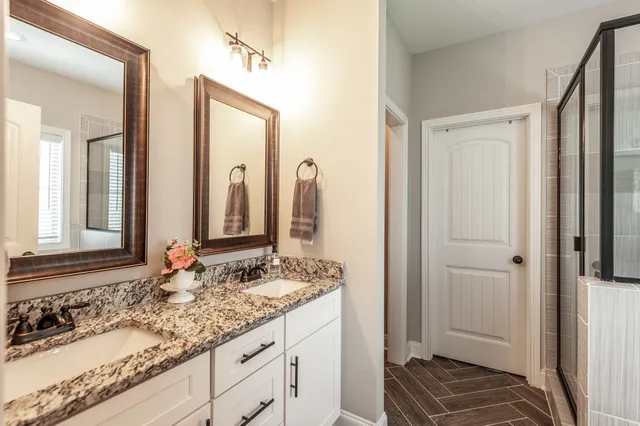 a bathroom with a granite countertop sink and a mirror