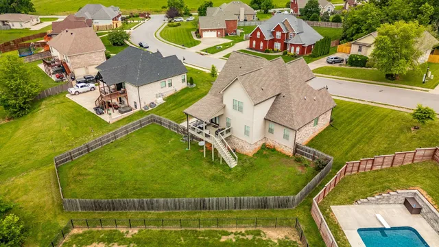 an aerial view of a house with swimming pool and outdoor seating