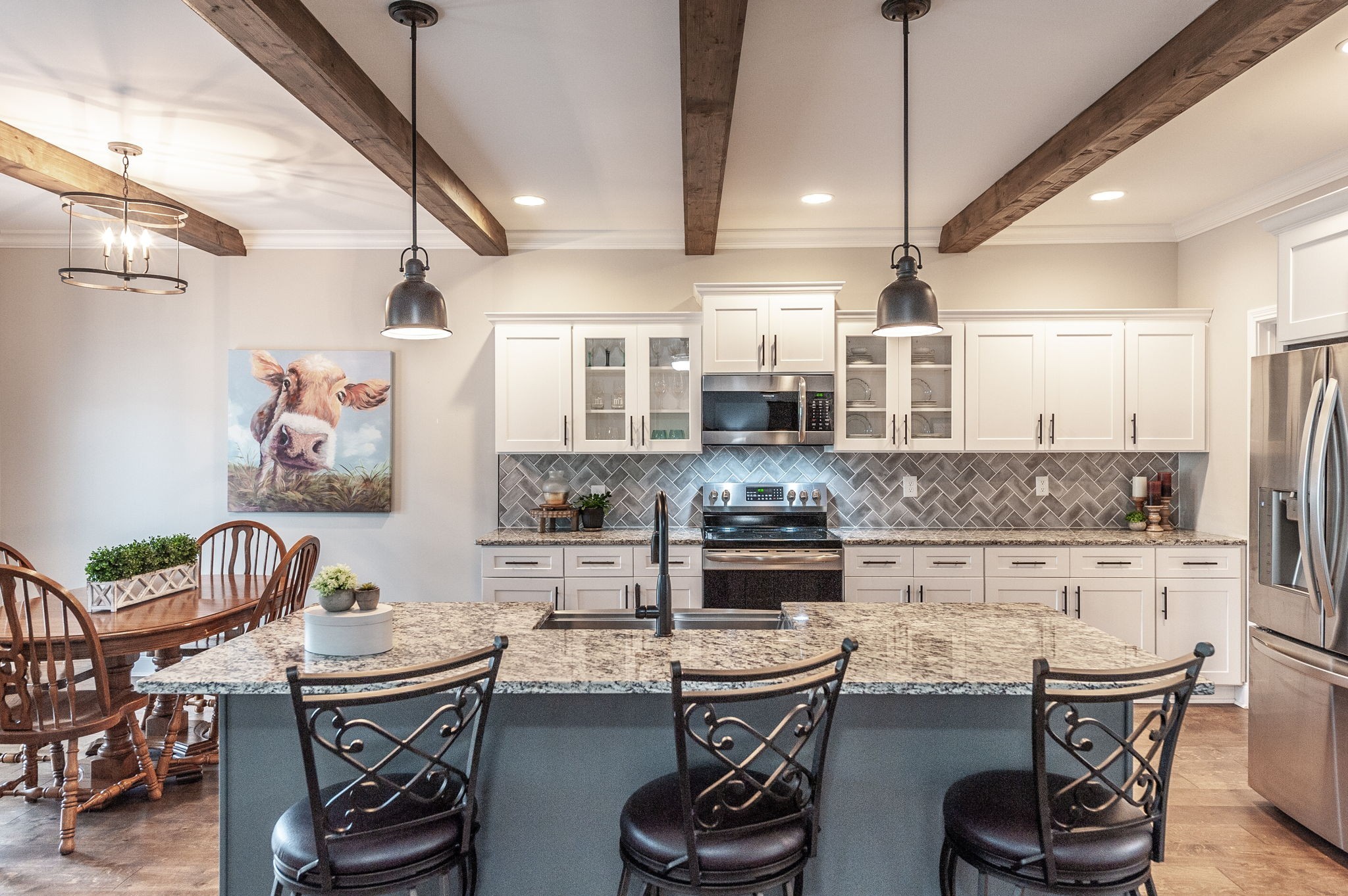 1184 Wicke Road Adams, TN 37010 - Photo 7 of 41 a kitchen with stainless steel appliances kitchen island granite countertop a dining table chairs sink and white cabinets