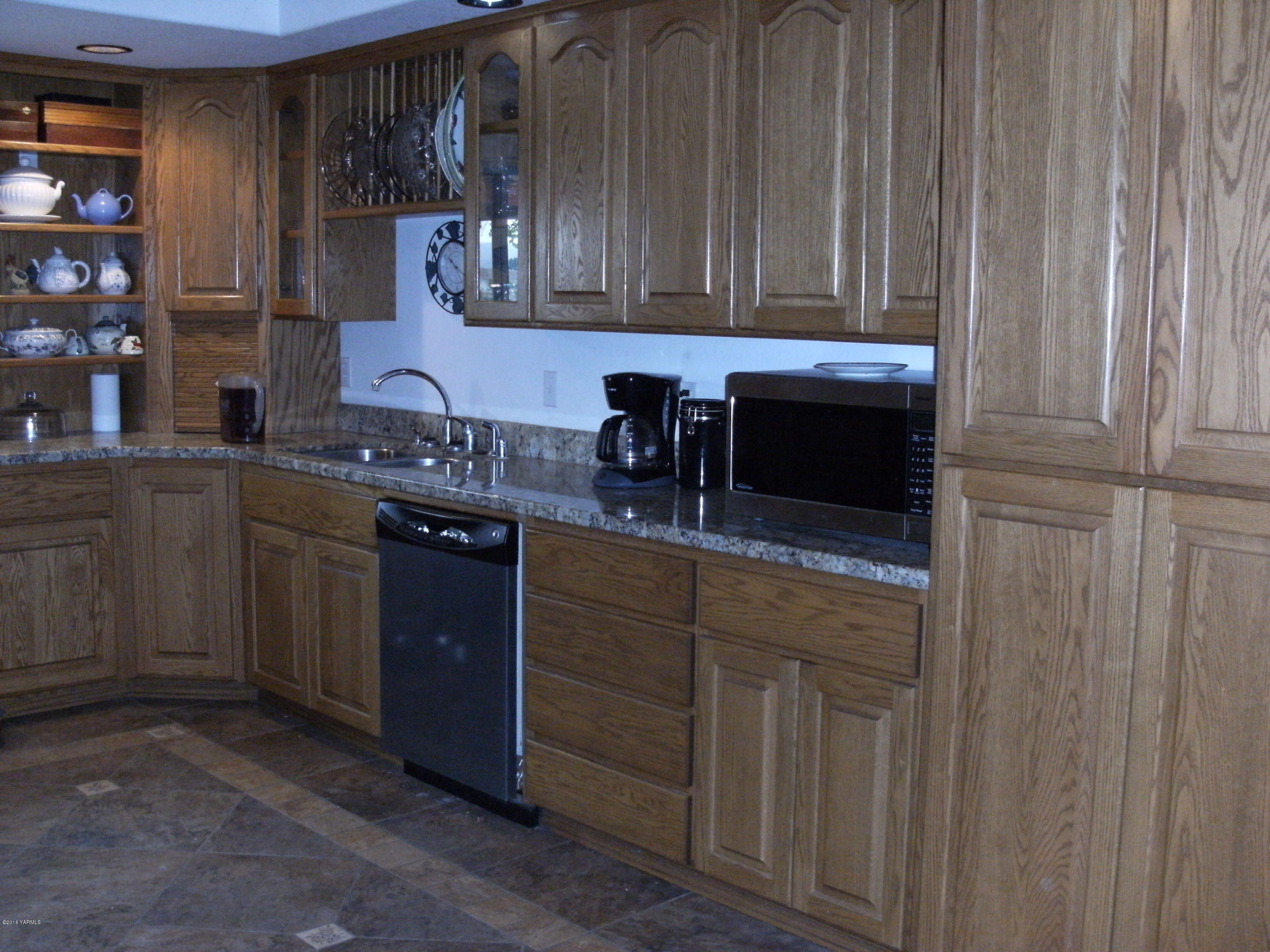 1009 Thornton Road Sunnyside, WA 98944 - Photo 4 of 18 a kitchen with stainless steel appliances granite countertop wooden cabinets a sink and dishwasher