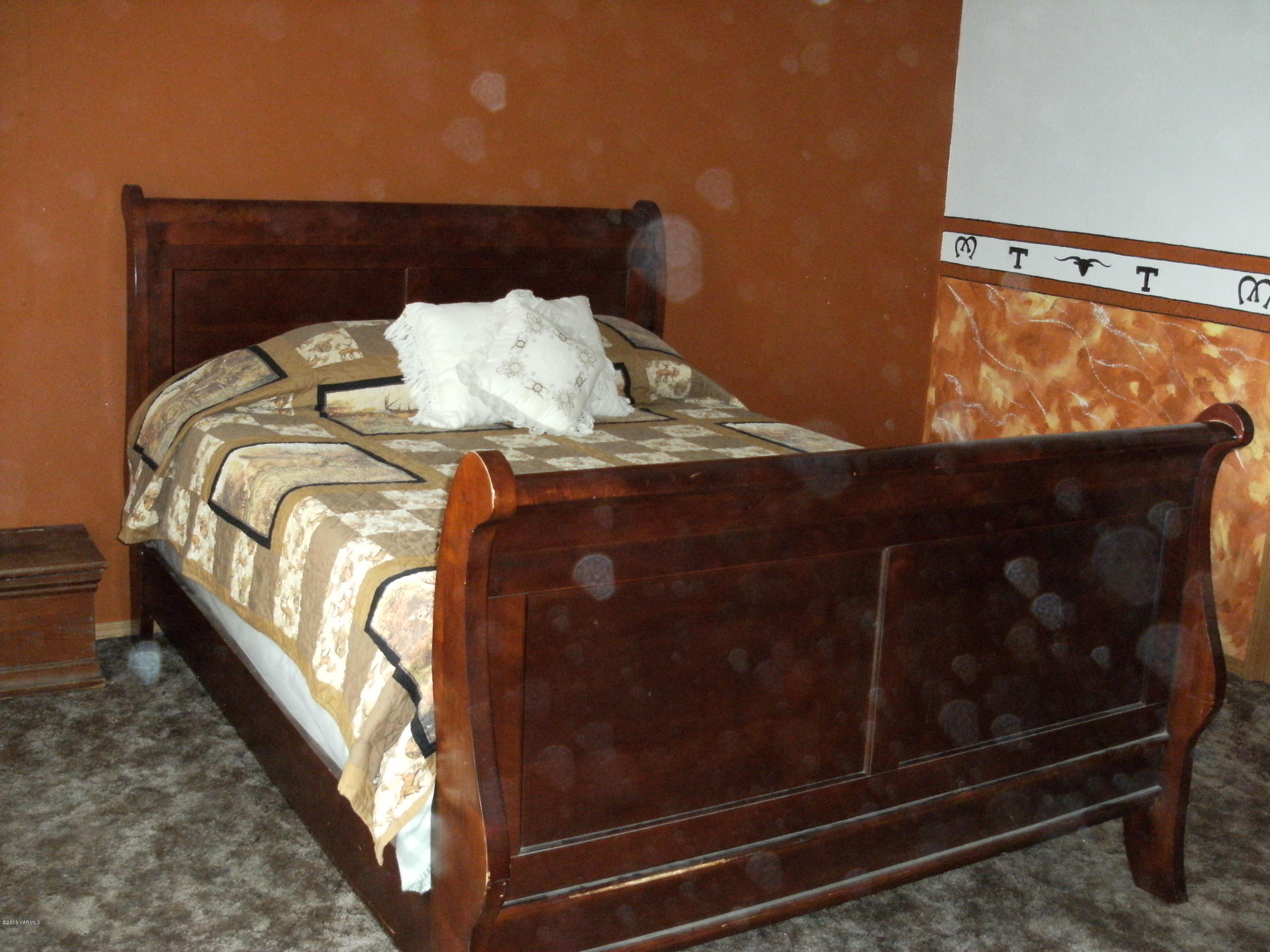 1009 Thornton Road Sunnyside, WA 98944 - Photo 7 of 18 a bed sitting in a bedroom next to a window